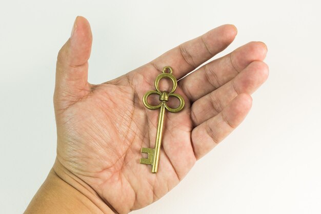 Vintage gold key in hand close up image.