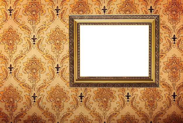 Vintage gold plated picture frame on retro wallpaper