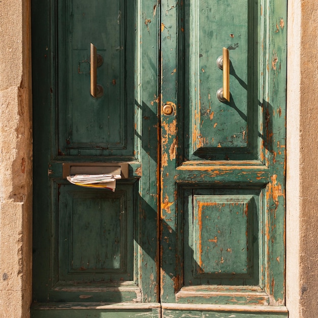 Vintage green worn door with mail and newspaper in the doorway Newsletter letters and news concept