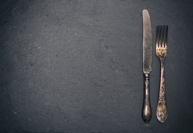 Vintage iron fork and knife on black