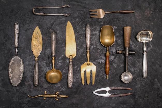 Vintage kitchen utensils and silverware on black background Retro background