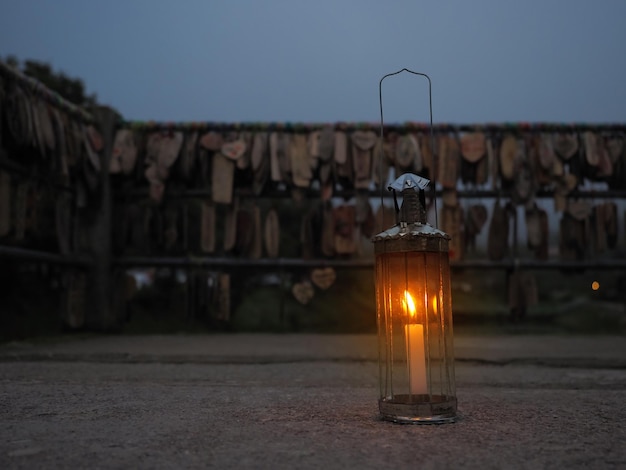 Vintage lamp with candle inside on street over wood name plates and tied to the bridge rail background in evening at E-tong village, Pilok mine, Kanchanaburi in Thailand.