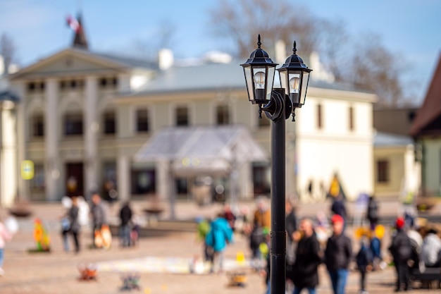 Vintage lantern pole isolated on a defocused city background background with copy space