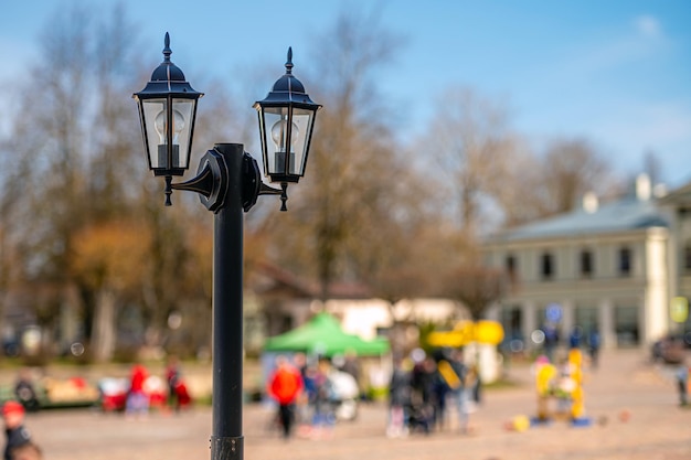 Vintage lantern pole isolated on a defocused city background background with copy space