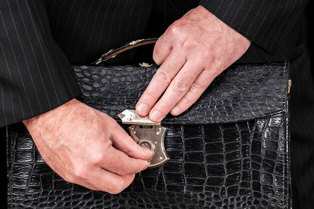 Vintage leather briefcase in the businessman hands, giving a bribe