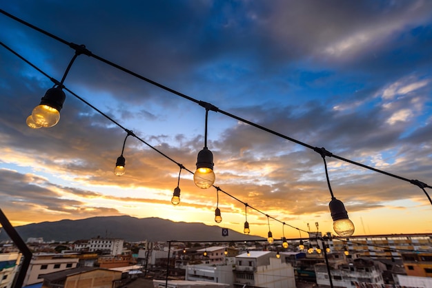 Vintage light bulbs on string wire against sunset sky decor in outdoors wedding event party