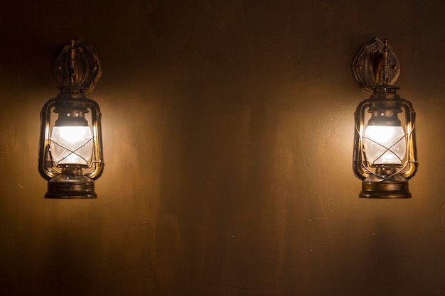 Vintage metal black of two lantern on an old wall of yellow color background