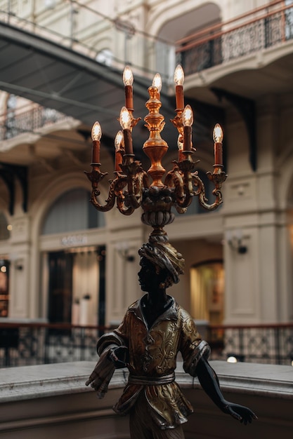 Vintage metal bronze statue of a man with a lamp burning candles in a classic interior