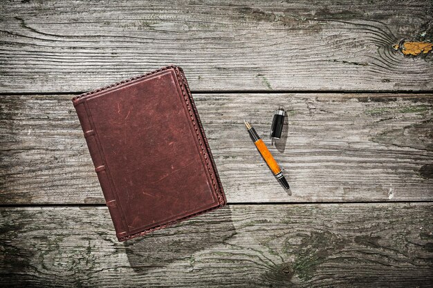 Vintage notepad and fountain pen on old wood boards