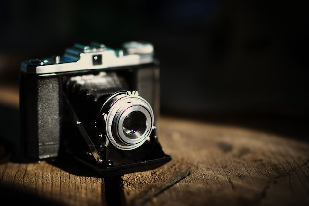 Vintage old camera on a wooden table. Retro style, nostalgia - Vintage effect photo