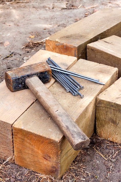 Vintage old rusty hammer and nails lying on wooden bars