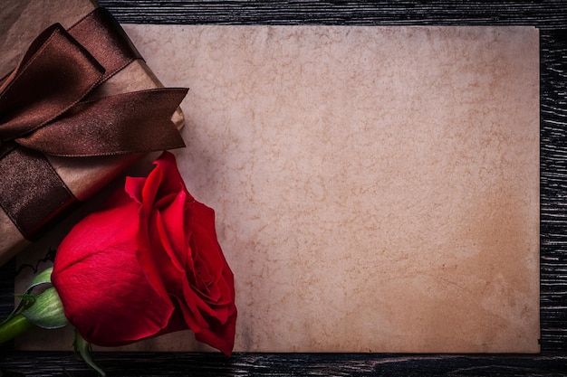 Vintage paper red rose wrapped giftbox on wooden board