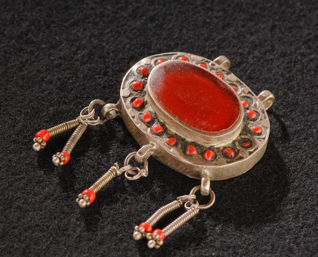 A Vintage pendant with precious red stone isolated on a black background Central Asian