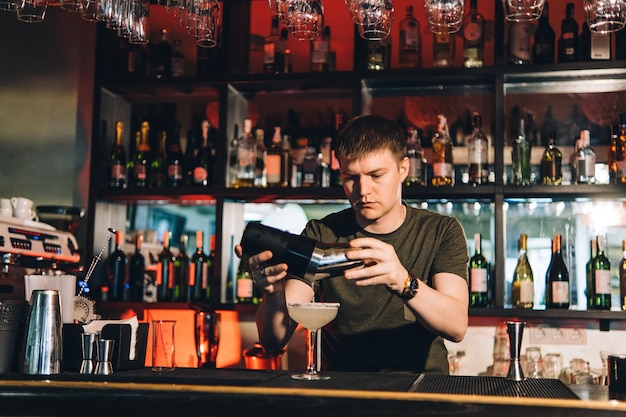 Vintage portrait of bartender creating cocktails at bar Close up of alcoholic beverage preparation