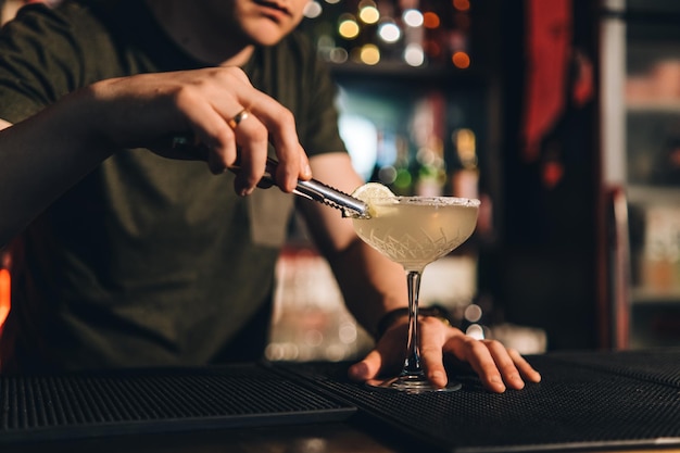 Vintage portrait of bartender creating cocktails at bar Close up of alcoholic beverage preparation