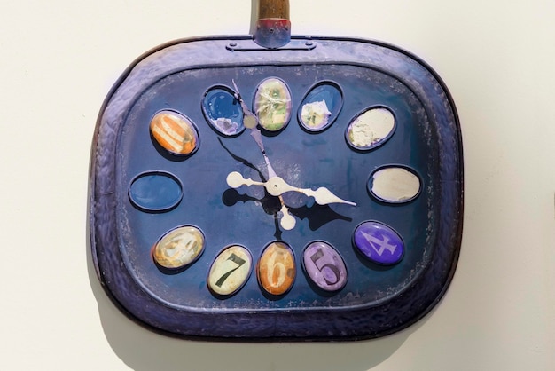 Vintage purple metallic clock on a white wall