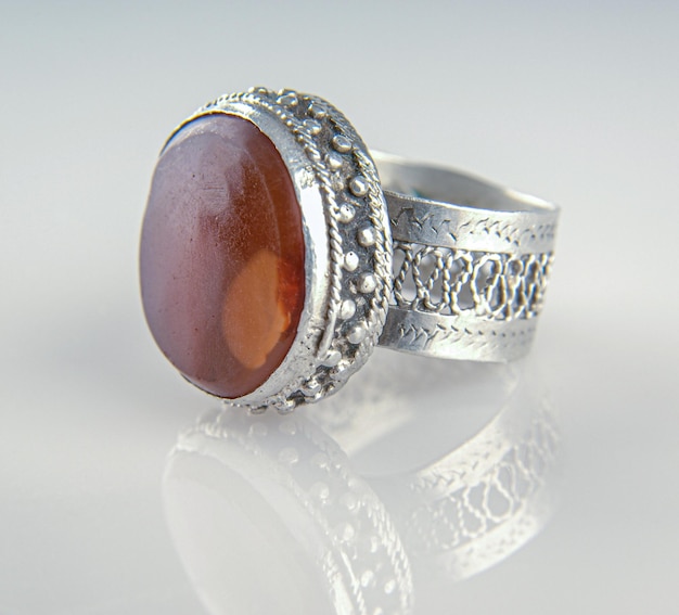 A Vintage silver ring with a precious big stone isolated on a reflective background