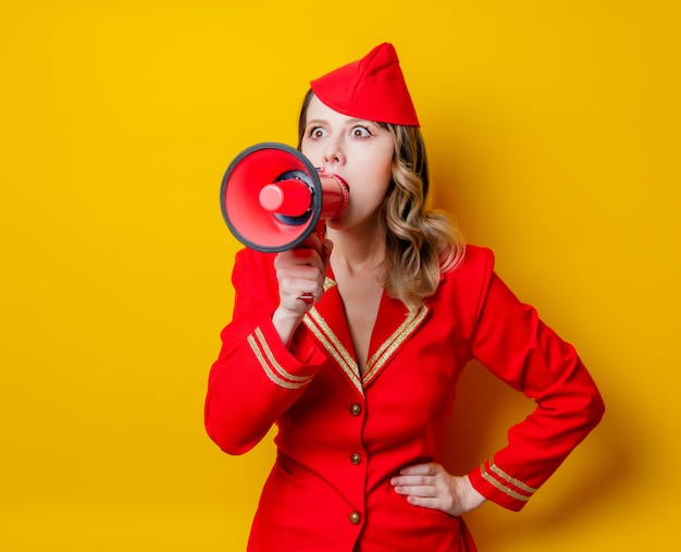 vintage stewardess wearing in red uniform with megaphone