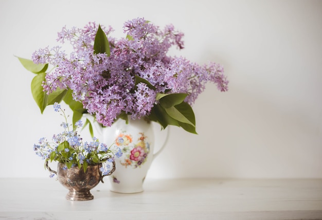 Vintage still life of lilac and forget-me-nots  flowers, Springtime. Gentle floral muted meadow flowers background.