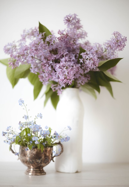 Vintage still life of lilac and forget-me-nots  flowers, Springtime. Gentle floral muted meadow flowers background.