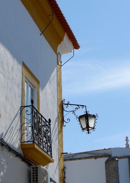 Vintage street lamp made of black metal hang on corner of rural Portuguese house Portugal village