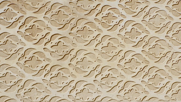 Vintage stucco ornate of beige colour on the wall outside downtown in Segovia Spain