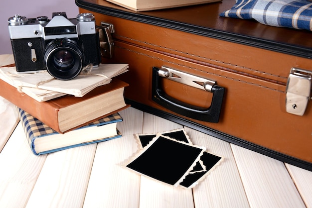 Photo vintage suitcase with clothes and books on table on dark background