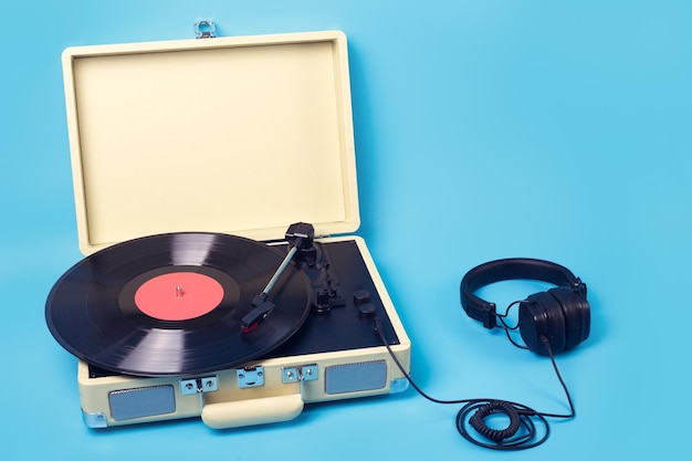 Vintage vinyl record player with headphones on isolated blue background