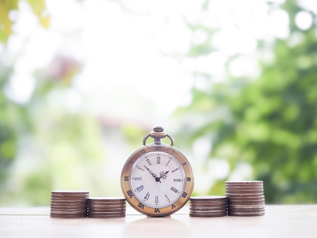 Photo vintage watch and stack of coins the concept of saving money for manage time to success business