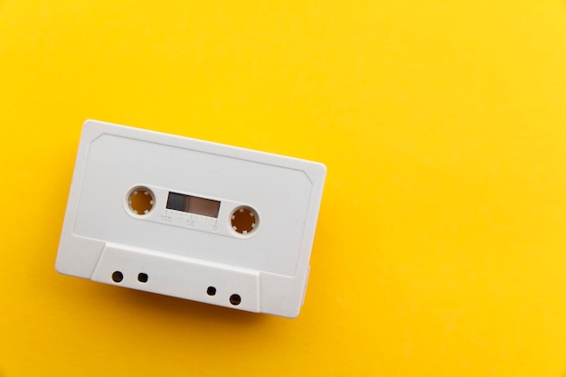 vintage white cassette tape on a bright yellow background.