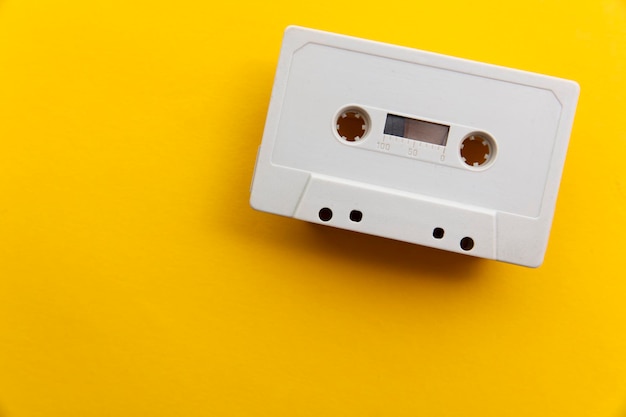 vintage white cassette tape on a bright yellow background.