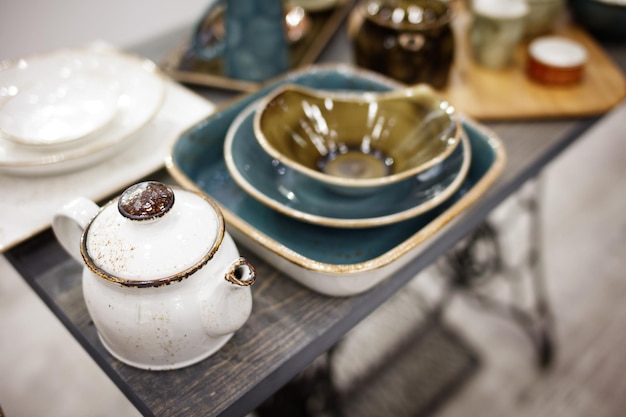 Vintage white teapot and utensils on a wooden table