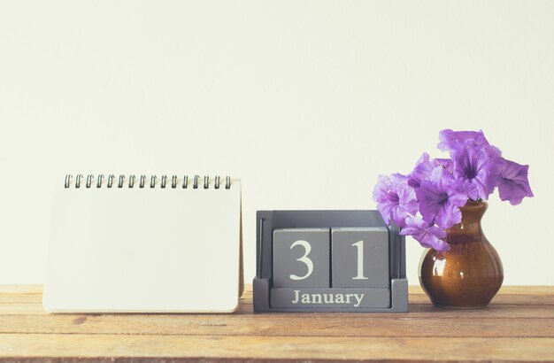 Vintage wood calendar for january day 31 on wood table with empty notebook