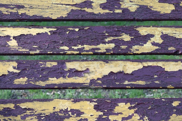 Vintage wooden bars of yellow color with cracked purple paint