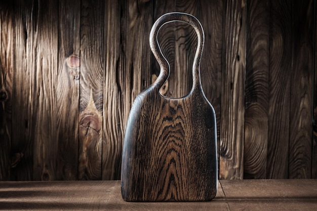 Vintage wooden chopping board on background of old wood