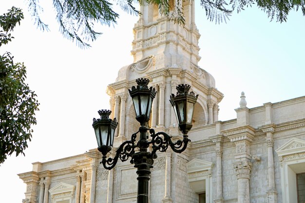 Vintage Wrought Iron Street Lamp Against White Volcanic Stone Church of Arequipa Cathedral in Peru