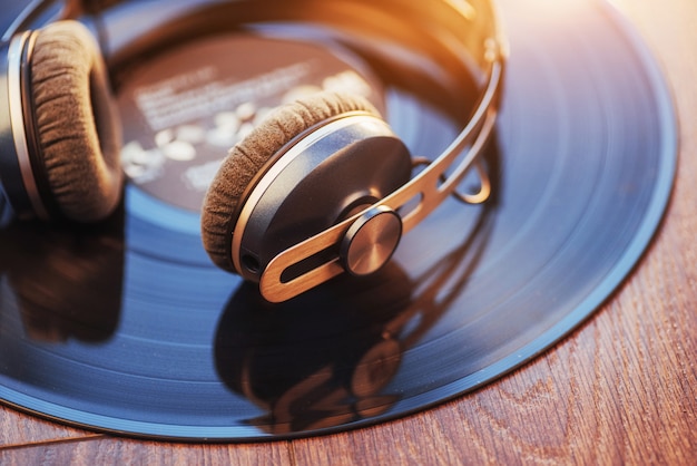 Vinyl record and headphone over wooden table