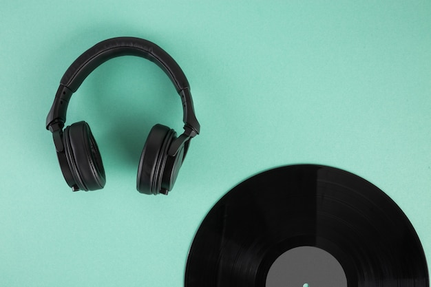 Vinyl record and headphones on abstract pastel background