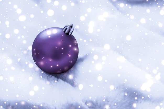 Violet Christmas baubles on fluffy fur with snow glitter luxury winter holiday design background