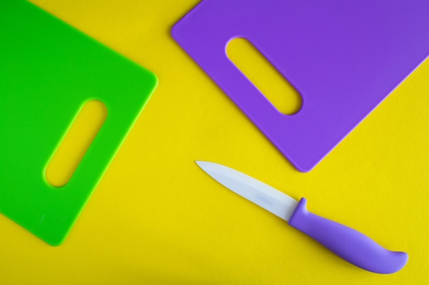 Violet  and green cutting boards  on the yellow surface.Top view.