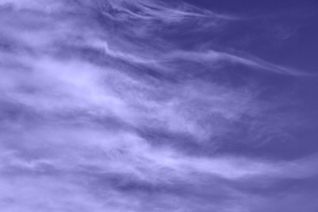 Violet sky with feather clouds. Very peri color, abstract background. Color of the year 2022