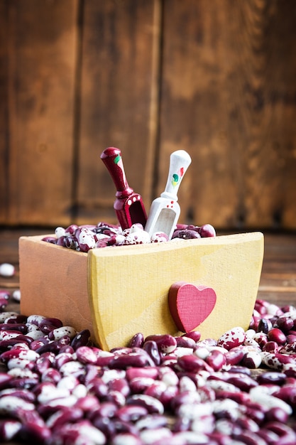 Violet with dots beans in wooden bow with two spoons