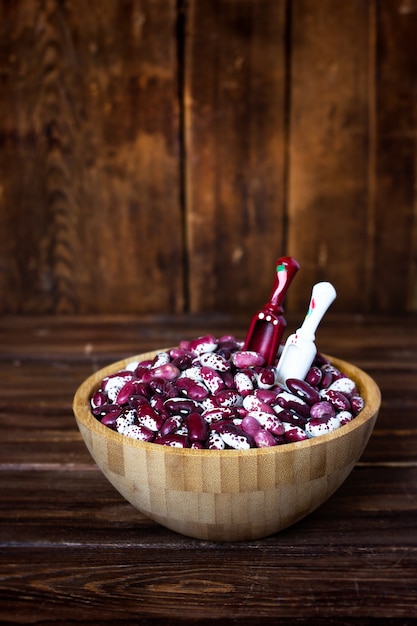 Violet with dots beans in wooden plate with two spoons