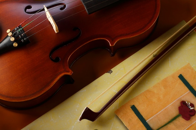 Violin and bow with book on yellow background