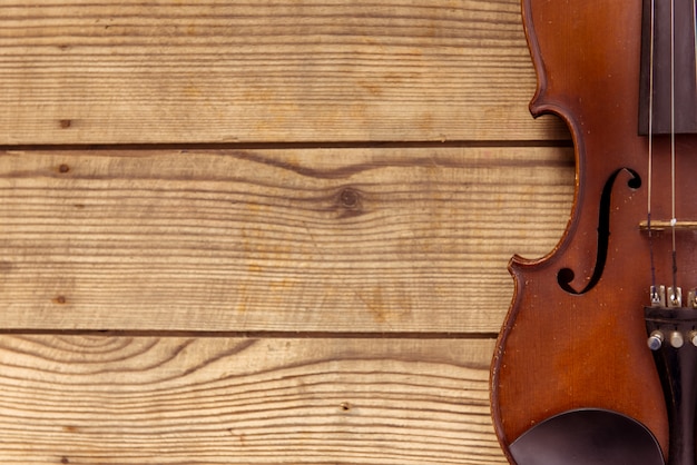 Violin lies on a wooden table background