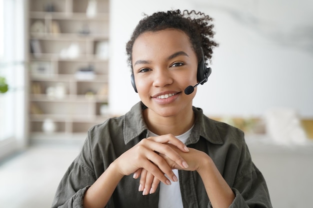 Virtual assistant Young afro woman in headset is operator of client support service from home