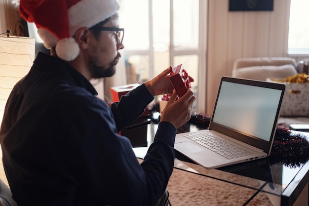 Virtual Christmas day house party Man smiling wearing Santa hat