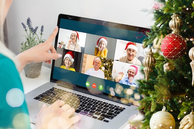 Virtual Christmas day house party. video conferencing Young man having video call via computer in the home office Online team gift opening conference calling.