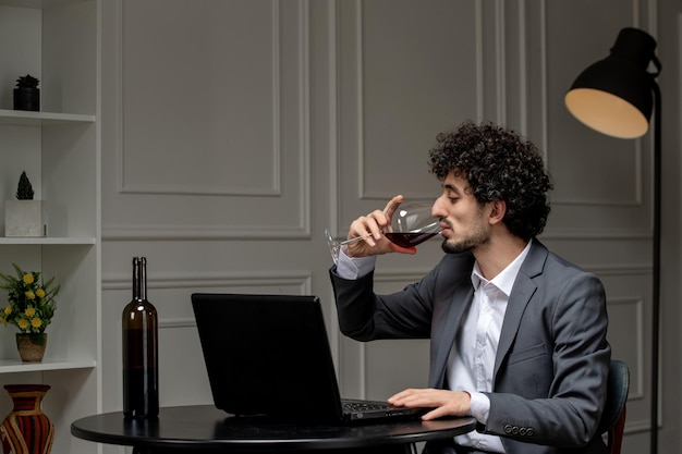 Virtual love handsome cute guy in suit with wine on a distance computer date drinking red wine