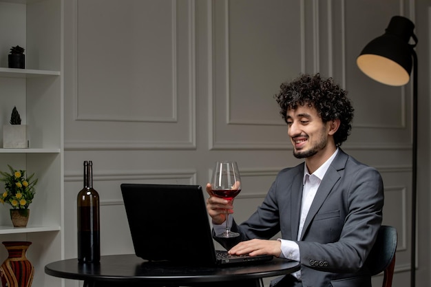 Virtual love handsome cute guy in suit with wine on a distance computer date drinking red wine